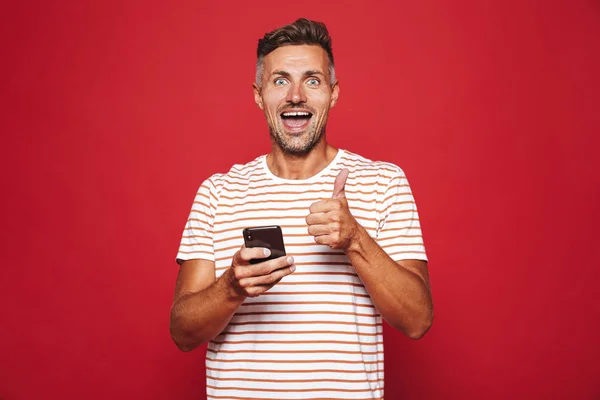 Bilden Optimistiska Kille 30S Randig Shirt Leende Och Hålla Mobiltelefon — Stockfoto