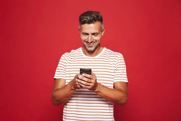 Εικόνα Του Καυκάσου Ανθρώπου Ριγέ Μπλουζάκι Χαμογελώντας Και Κρατώντας Κινητό — Φωτογραφία Αρχείου