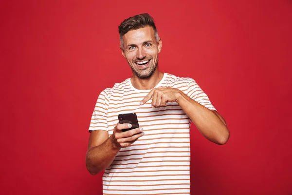 Vrolijke Man 30S Gestreept Shirt Glimlachend Houden Van Mobiele Telefoon — Stockfoto