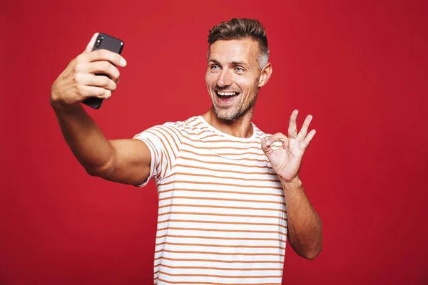 Retrato Hombre Alegre Pie Sobre Fondo Rojo Tomando Una Selfie — Foto de Stock