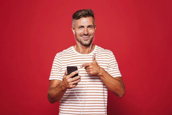 Retrato Hombre Sonriente Pie Sobre Fondo Rojo Escuchando Música Con — Foto de Stock