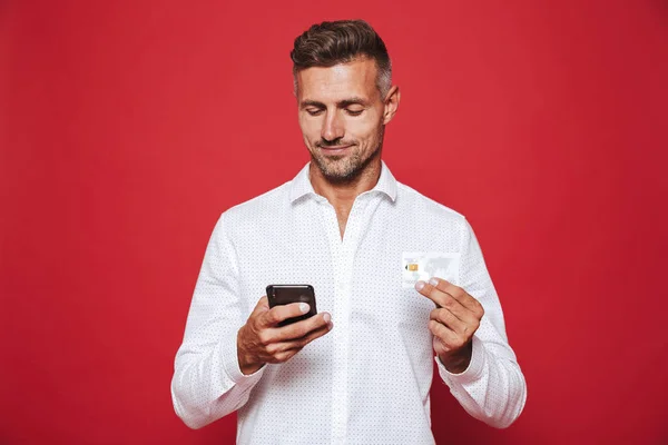Bild Glada Mannen Vit Skjorta Holding Kreditkort Och Smartphone Isolerade — Stockfoto