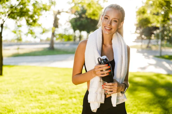 Wizerunek Szczęśliwy Młody Sportowe Kobiety Zewnątrz Trawie Trzymając Butelkę Wodą — Zdjęcie stockowe