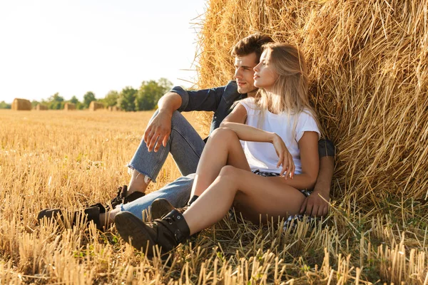 Lächelndes Junges Paar Sitzt Zusammen Auf Einem Heuhaufen Feld — Stockfoto