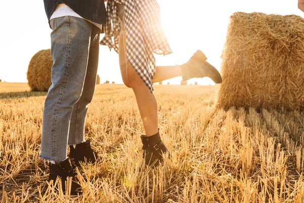 男と女の干し草の山や晴れた日の中にキスの束とゴールデン フィールドを歩いての写真をトリミング — ストック写真