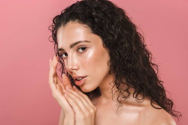Kamera seyir pembe arka plan üzerinde izole sağlıklı cilt poz ile çok güzel genç kadın portresi.