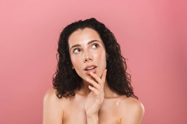 Bir kenara görünümlü pembe arka plan üzerinde izole sağlıklı cilt poz ile şaşırtıcı güzel genç kadın portresi.