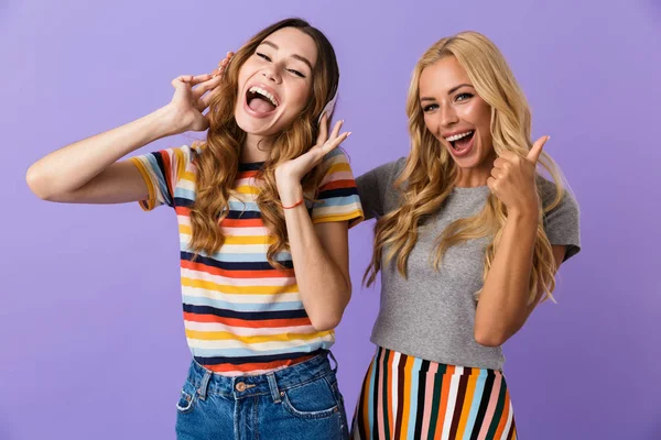 Две Довольно Счастливые Молодые Девушки Друзья Стоят Изолированно Фиолетовом Фоне — стоковое фото
