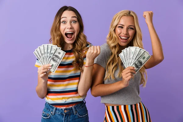 Two Pretty Happy Young Girls Friends Standing Isolated Violet Background — Zdjęcie stockowe