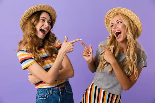 Dos Amigas Guapas Sombreros Verano Aisladas Sobre Fondo Violeta Apuntándose — Foto de Stock