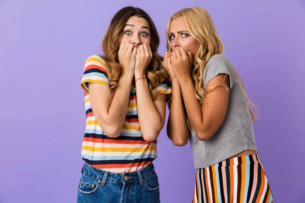 Две Напуганные Юные Подружки Стоят Изоляции Фиолетовом Фоне Прикрывая Рот — стоковое фото
