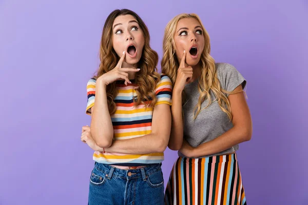 Duas Jovens Amigas Muito Chocadas Isoladas Sobre Fundo Violeta Olhando — Fotografia de Stock