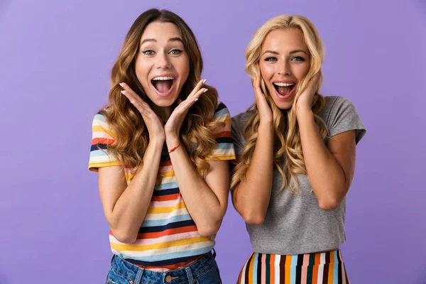 Two Pretty Excited Young Girls Friends Standing Isolated Violet Background — Stock Photo, Image