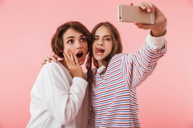 Görüntü harika kadın arkadaş pembe duvar arka plan al bir sefie cep telefonuyla izole.
