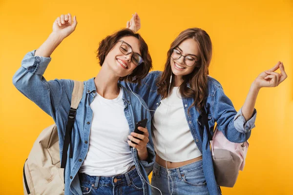 Imagen Alegres Amigas Felices Aisladas Sobre Fondo Pared Amarillo Usando — Foto de Stock