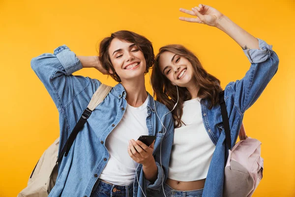 Imagen Alegres Amigas Felices Aisladas Sobre Fondo Pared Amarillo Usando — Foto de Stock