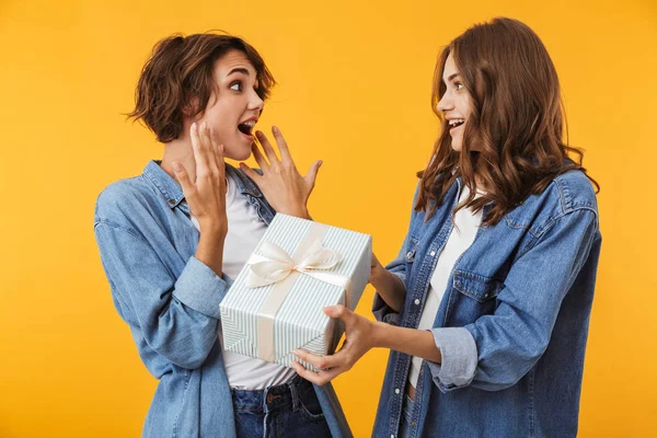 Imagen Alegres Amigas Felices Aisladas Sobre Fondo Pared Amarillo Sosteniendo — Foto de Stock