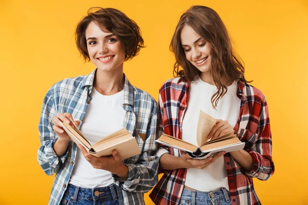 Foto Přátel Mladé Ženy Vystupují Nad Žlutým Pozadím Drží Knihy — Stock fotografie