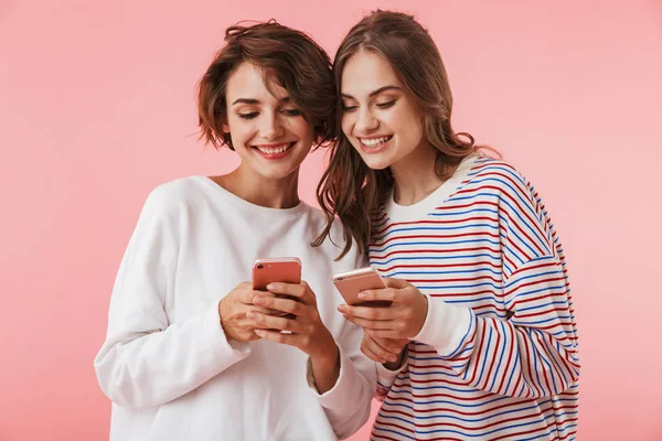 Imagen Amigas Felices Aisladas Sobre Fondo Pared Rosa Usando Teléfonos — Foto de Stock