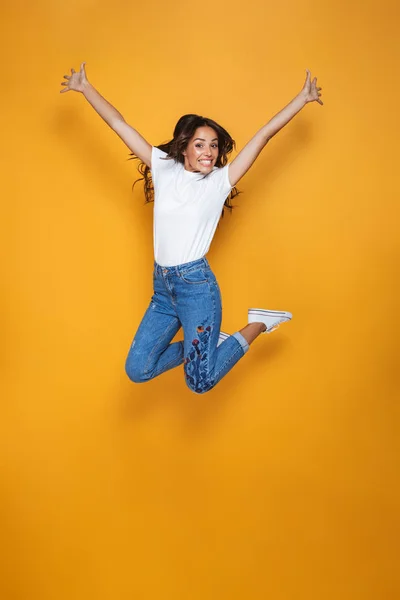 Full Length Portrait Cheerful Girl Long Dark Hair Jumping Yellow — Stock Photo, Image