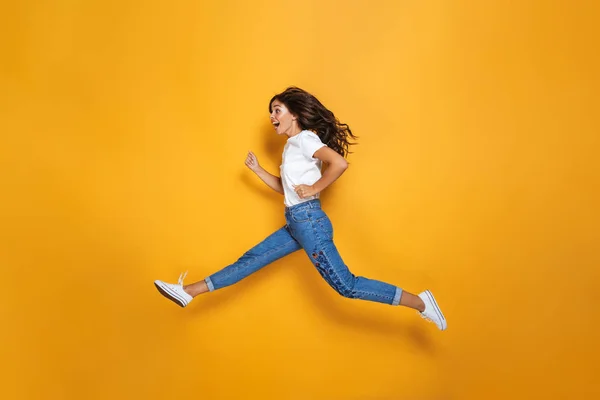 Uzak Bir Neşeli Kız Sarı Arka Plan Üzerinde Atlama Uzun — Stok fotoğraf