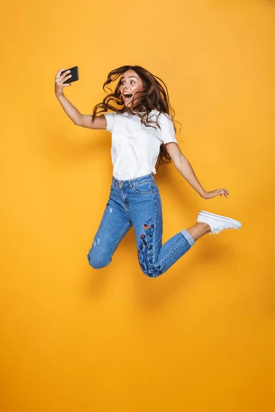 Full Length Portrait Cheerful Girl Long Dark Hair Jumping Yellow — Stock Photo, Image
