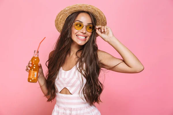 照片的魅力女人20S 戴墨镜和草帽喝柠檬水从玻璃瓶查出粉红色背景 — 图库照片