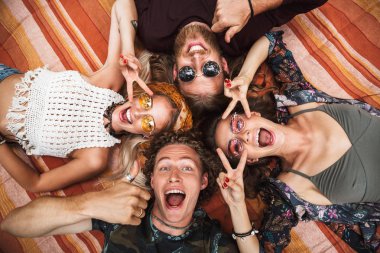 Fotoğraf çekici hippiler çocuklar ve gülüyor ve battaniye daire açık içinde yatan kız
