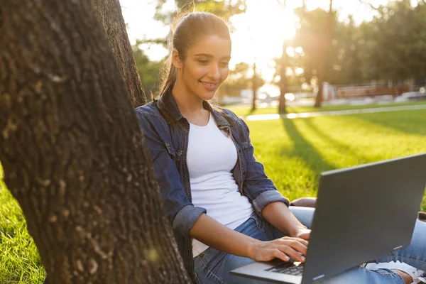 图像的惊人美丽的年轻女子在公园使用笔记本电脑的学生 — 图库照片