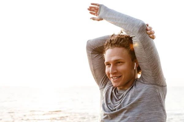 Imagen Joven Guapo Deportista Parado Playa Escuchando Música Con Auriculares —  Fotos de Stock