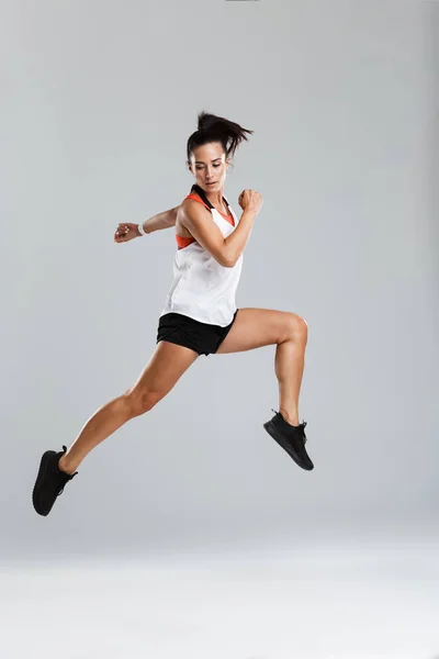 一个强大的年轻体育女子跳跃的形象使体育锻炼隔离室内 — 图库照片