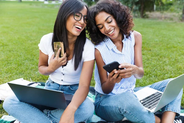 Two Smiling Young Girls Students Sitting Grass Campus Studying Holding — Stock Photo, Image