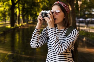Heyecanlı şok genç güzel kadın açık havada yürüyüş fotoğraf makinesi ile görüntü.