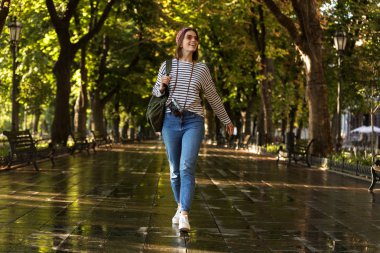 Heyecanlı güzel genç mutlu kadın açık havada yürüyüş sırt çantası ve kamera ile görüntü.