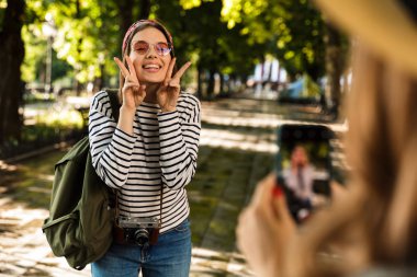 Cep telefonuyla fotoğrafını almak mutlu hanımlar arkadaşlar açık havada yürüyüş sırt çantaları ile fotoğraf.