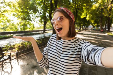 Açık havada boşaltmak gösterilen kamera tarafından bir selfie almak fotoğraf genç güzel heyecanlı şok kadın.