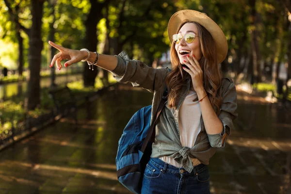 興奮してショックを受けた美しい若い幸せと一緒に歩いている女性アウトドア バックパック ポイントのイメージ — ストック写真
