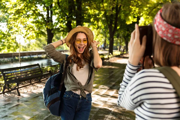 Genç kadın arkadaşlar açık havada yürüyüş sırt çantaları ile fotoğrafını çekin bir fotoğraf kamera tarafından.