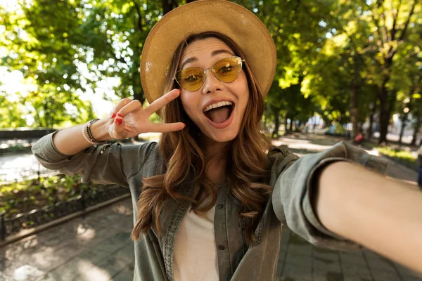 Cheerful Young Girl Hat Sunglasses Walking Park Taking Selfie — Stock Photo, Image