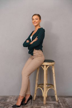 Görüntü gri duvar arka plan üzerinde çarpı işareti silah ile izole poz güzel kadın.