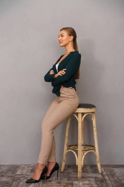 Görüntü gri duvar arka plan üzerinde çarpı işareti silah ile izole poz güzel kadın.