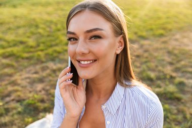 Cep telefonu açık havada üzerinde konuşurken neşeli genç kızın yakın çekim