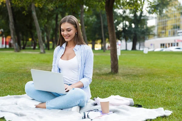 美丽的年轻漂亮的女人在公园户外使用笔记本电脑的形象 — 图库照片