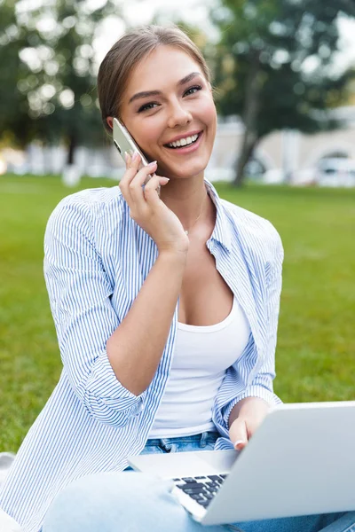 Sorrindo Jovem Passando Tempo Parque Falando Celular Usando Computador Portátil — Fotografia de Stock