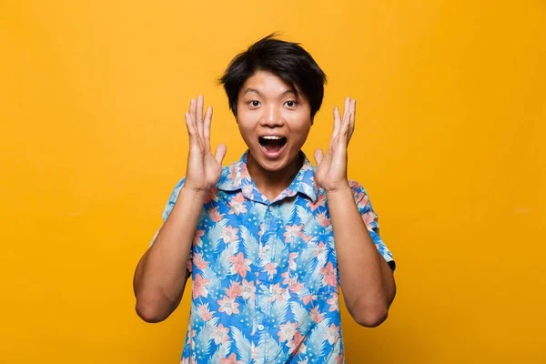 黄色の背景に分離されたショックを受けて興奮して感情的な若いアジア人のポーズ画像 — ストック写真