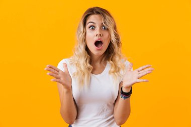 Merak ve sarı arka plan üzerinde izole çığlık temel giyim heyecanlı sarışın kadın fotoğrafı