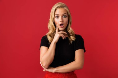Heyecanlı sarışın kadın 20'li yaşlarda ifade sürpriz açık ağızlı Studio kırmızı arka plan üzerinde izole portresi