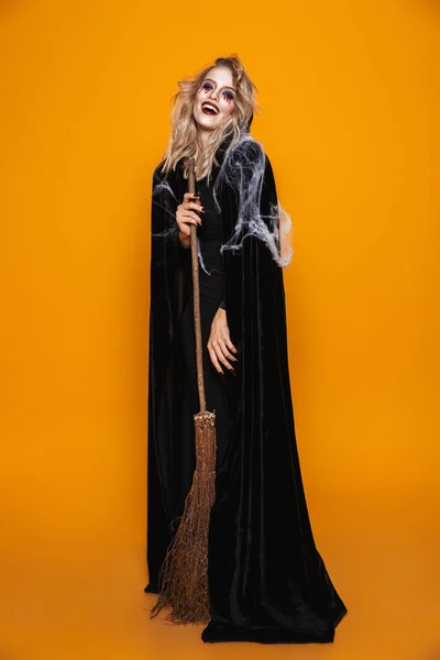 Imagem Completa Bruxa Perigosa Usando Traje Preto Maquiagem Halloween Segurando — Fotografia de Stock