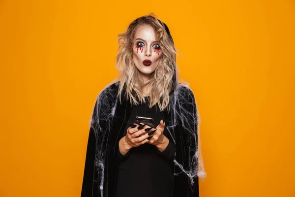 Glada Kvinna Klädd Svart Dräkt Och Halloween Makeup Håller Mobiltelefon — Stockfoto