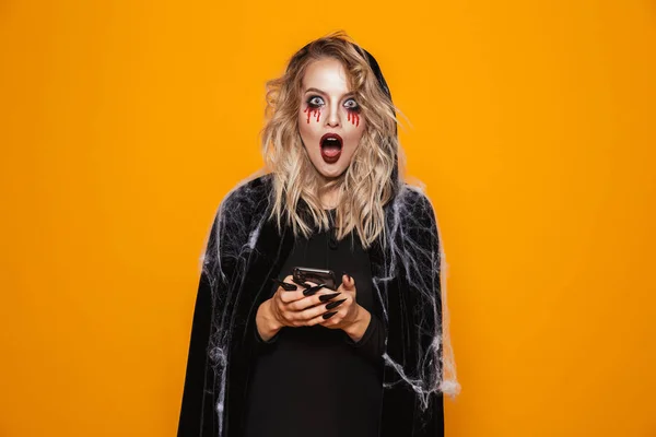 Blond Kvinna Klädd Svart Dräkt Och Halloween Makeup Håller Mobiltelefon — Stockfoto
